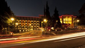 Un hotel con varios pisos, iluminación exterior y una entrada bien iluminada.