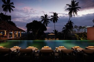 Una piscina al aire libre, sombrillas, sillones reclinables de piscina