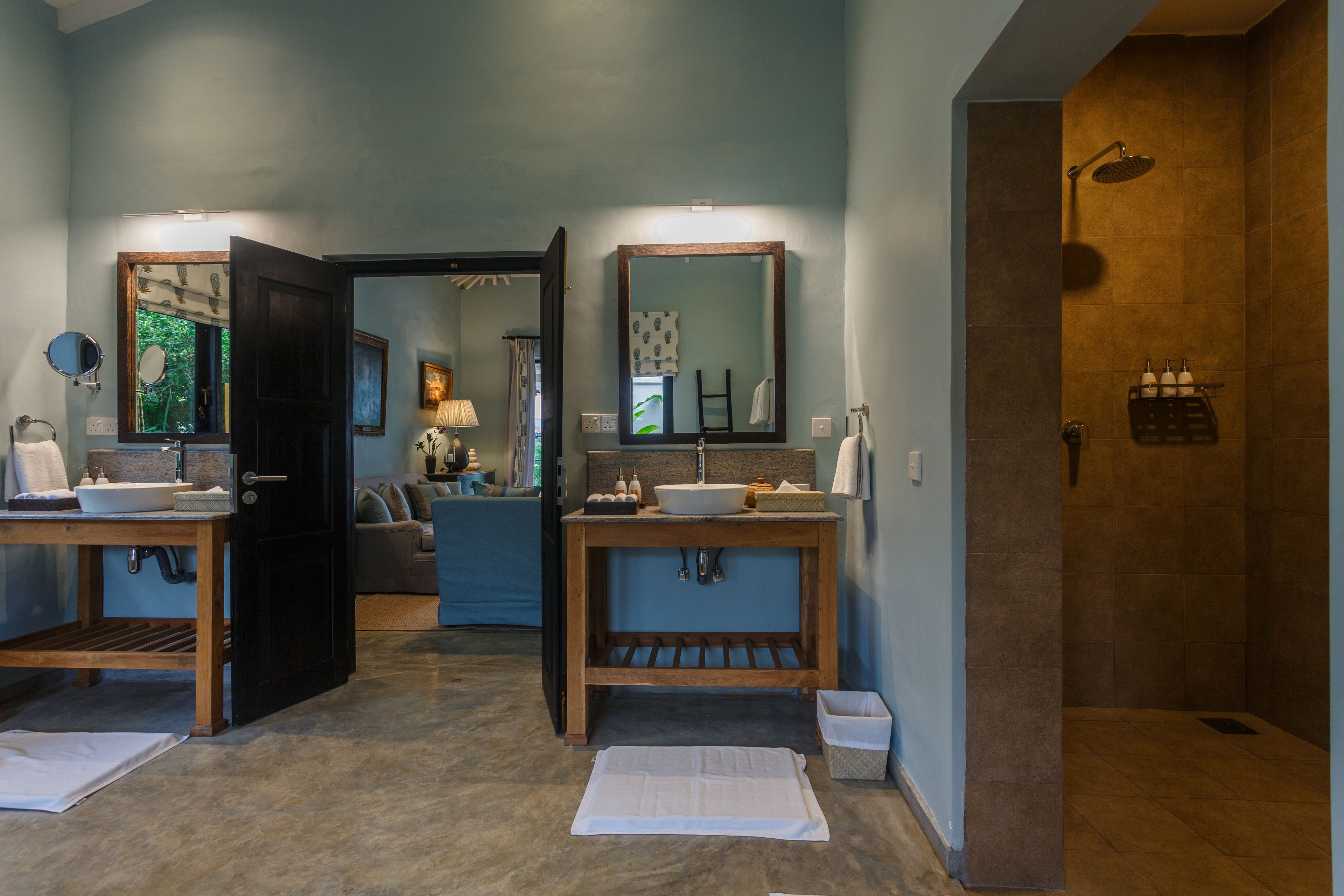 A bathroom with two sinks, a shower, and a mirror.