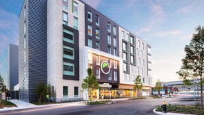 A modern hotel with a prominent logo, a central entrance, and a parking area. - Element by Marriott Boston Seaport District (Boston)
