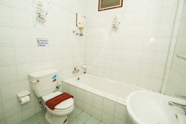 A bathroom with a toilet, bathtub, and sink.