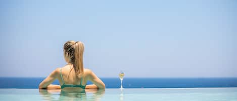 A person in a pool with a clear view of the ocean.