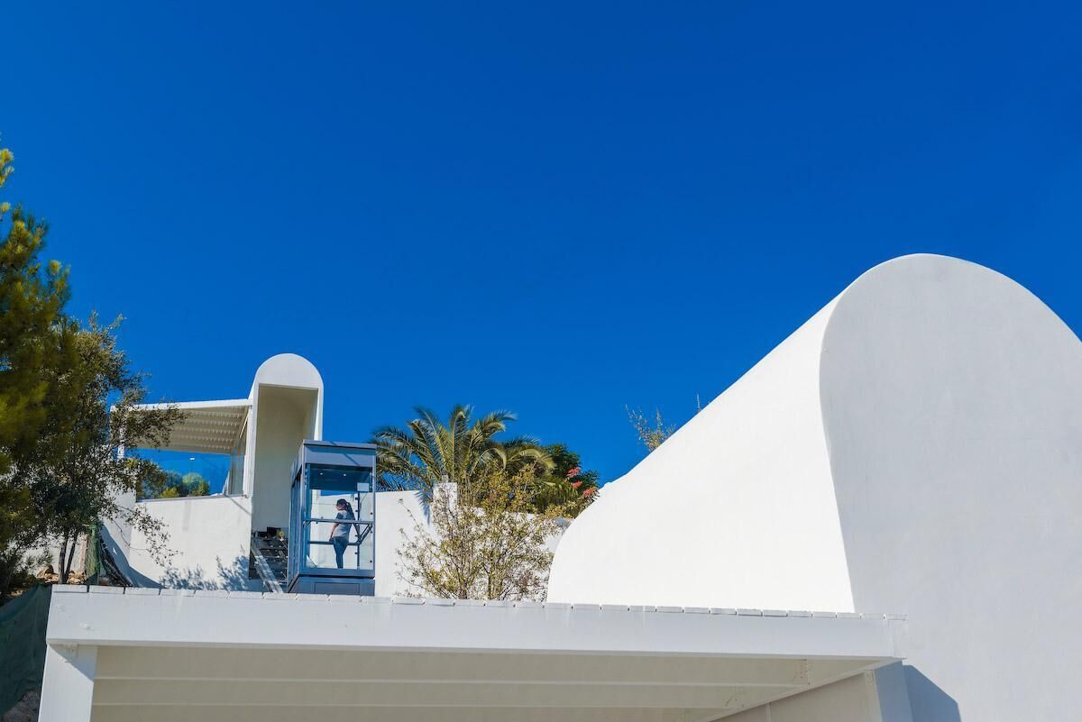 A modern building with a white facade and a curved structure.