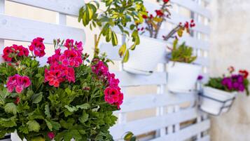 Un recinto in legno bianco con vasi di piante e fiori.