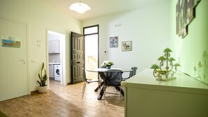 A modern kitchen with a dining area, a washing machine, and a potted plant. - Trapani Home (Trapani)