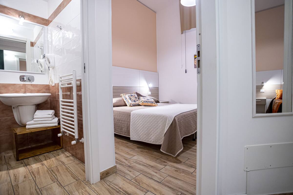 Un baño moderno con lavamanos, espejo y perchero.