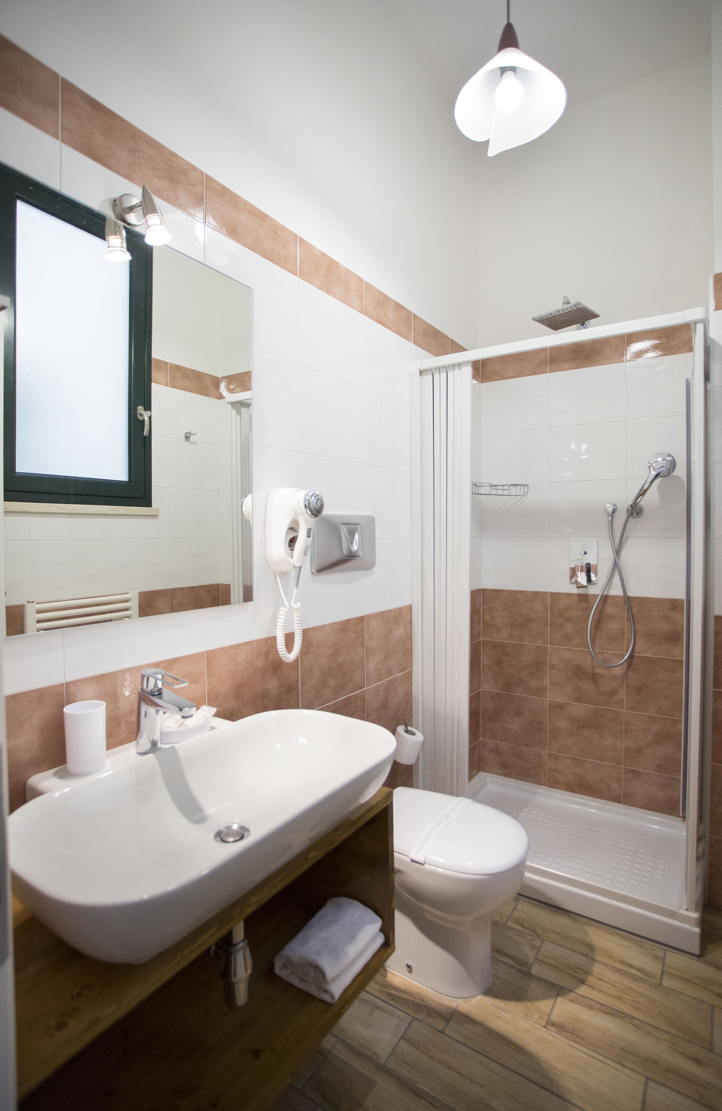 A bathroom with a sink, toilet, and shower.