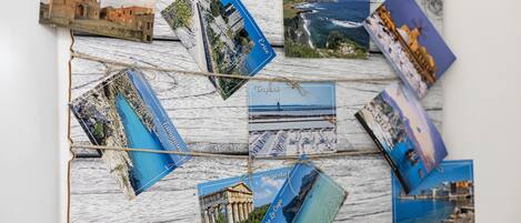 A wall with multiple travel photographs pinned on it, each labeled with a destination name.