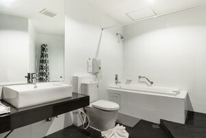 Un baño moderno con lavamanos, inodoro y bañera blancos.