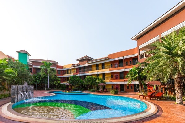 A hotel with a swimming pool, multiple balconies, and lush greenery. - Prelude Hotel (Kanchanaburi)