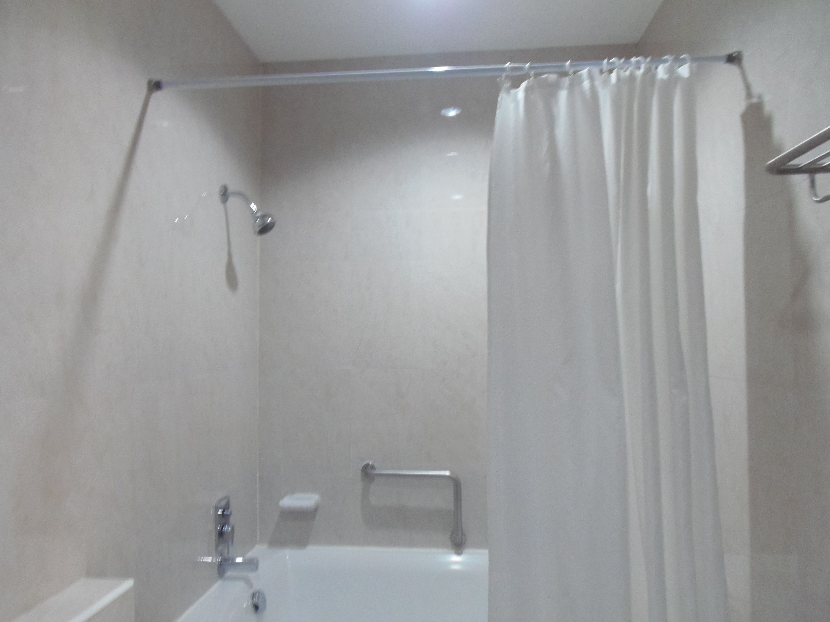 A modern bathroom with a bathtub, shower, and toilet.