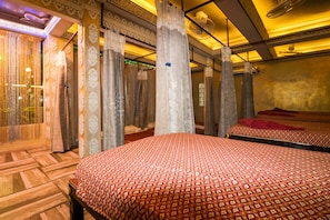 A hotel room with two beds, ornate curtains, and a patterned bedspread. - Natural Beach Hotel Pattaya (Pattaya)