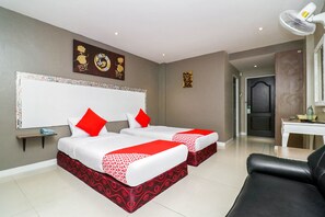 Une chambre d’hôtel avec deux lits, un bureau, une chaise et une porte.