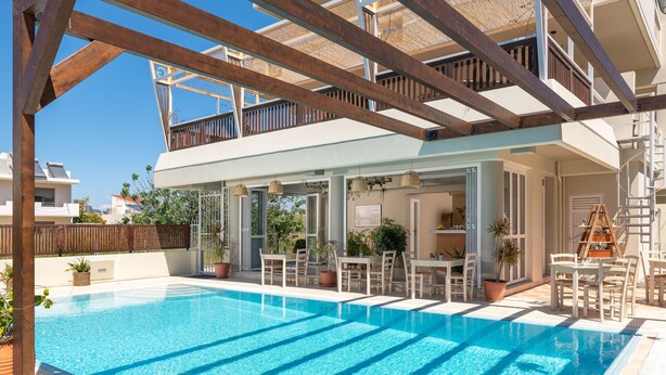 Una piscina con muelle de madera y zona de estar al aire libre.