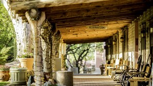 A rustic wooden building with a sign reading "RESERVATIONS" and outdoor seating with wheelchairs. - Tanque Verde Ranch (Tucson)