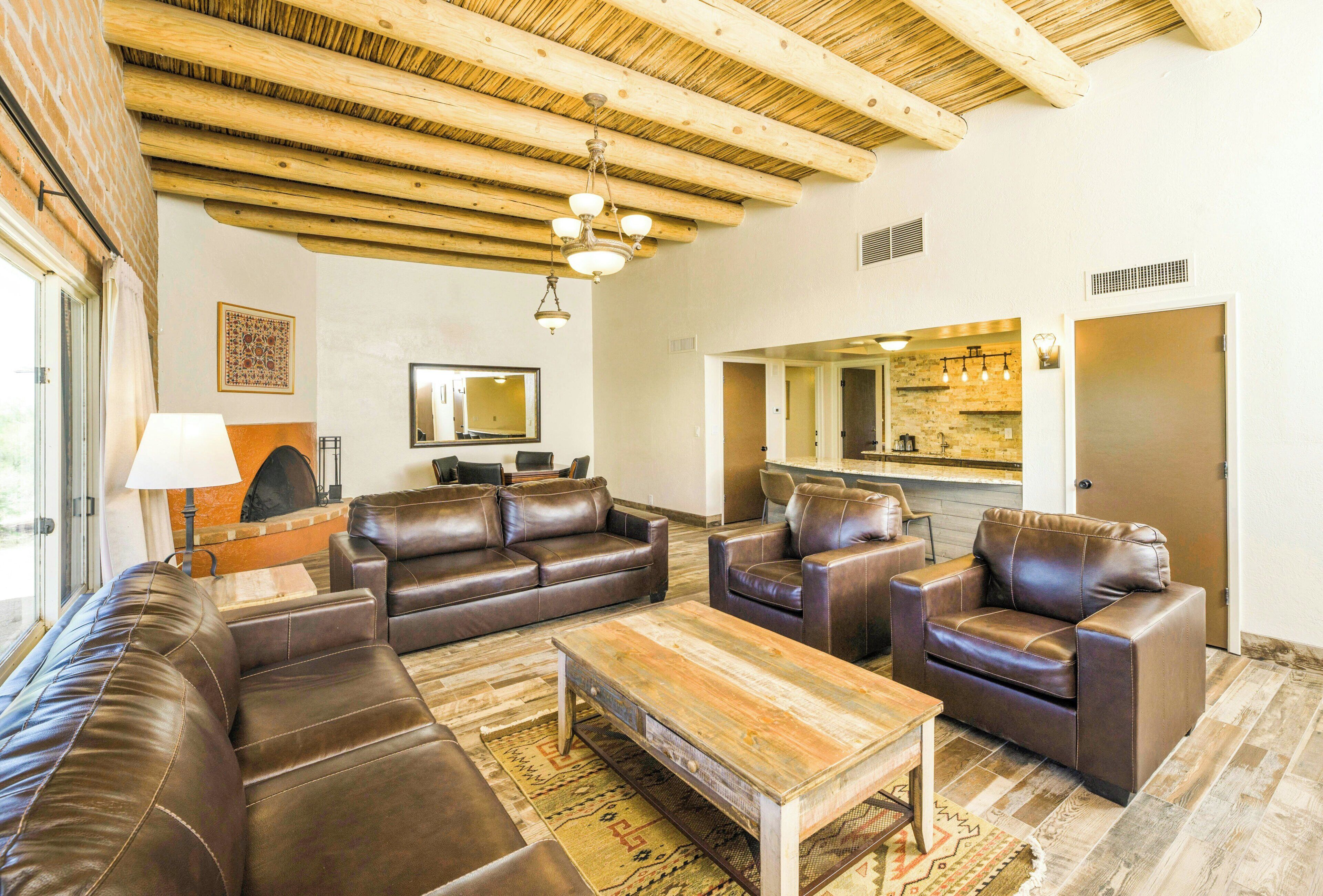 A living room with leather sofas, a wooden coffee table, and a fireplace.