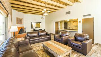A living room with leather sofas, a wooden coffee table, and a fireplace.