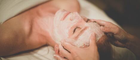 A person lying down with a facial mask applied.