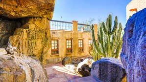A desert-themed interior with rock formations, cacti, and a balcony with a railing. - Tanque Verde Ranch (Tucson)