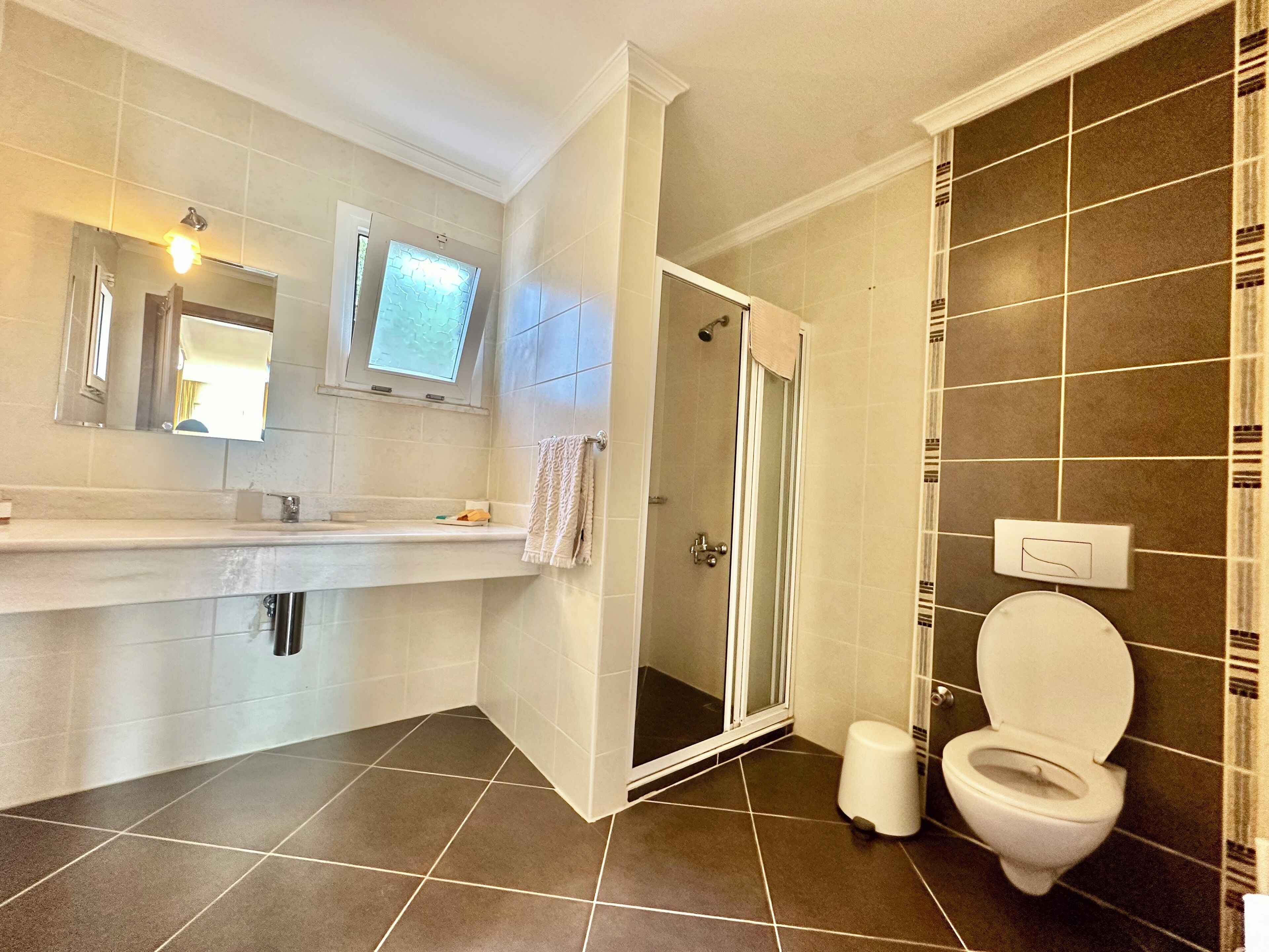 Un baño moderno con ducha, inodoro y tocador.