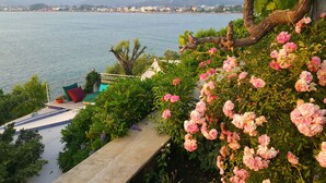 A balcony with a view of a body of water and a cityscape in the distance. - Ece Hotel Sovalye Island (Fethiye)