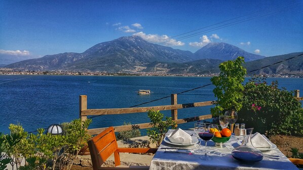 Mesa lista para comer con vista a un lago y montañas.