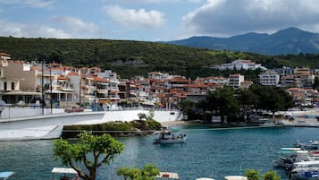 A coastal town with a marina, boats, and buildings along the waterfront.