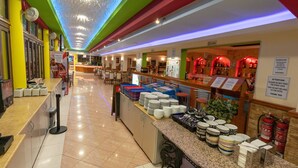 Een hotel lobby met een buffetgedeelte, een receptiebalie en een bar.