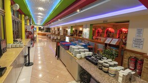 Un hall d’hôtel avec un long comptoir, un espace repas et un bar.