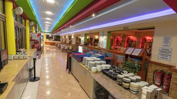 A hotel lobby with a buffet area, a reception desk, and a bar.