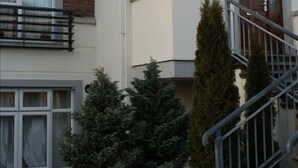 A two-story residential building with a white facade, brick lower section, and a small balcony. - Gort na Coiribe Holiday Village (Galway)