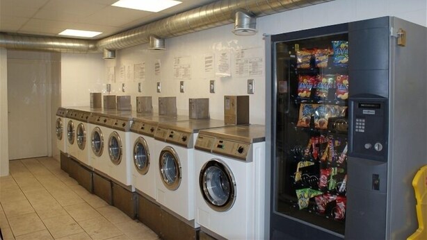 A laundromat with multiple washing machines and a vending machine. - Gort na Coiribe Holiday Village (Galway)
