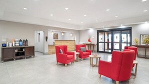 A spacious lobby with red armchairs, a reception desk, and a coffee station. - Comfort Inn & Suites Slidell - New Orleans Area (Slidell)