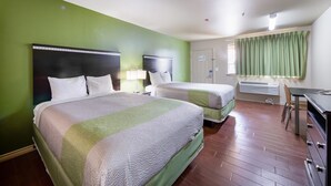 A hotel room with two beds, a desk, and a chair. - Eagle Ford Inn (Floresville)