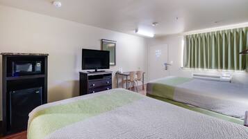 A hotel room with two beds, a desk with a chair, a television, and a microwave.