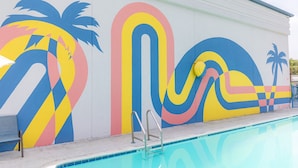 Una piscina con un mural colorido en la pared contigua.