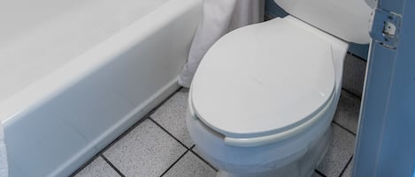 A bathroom with a bathtub, toilet, and shower curtain.