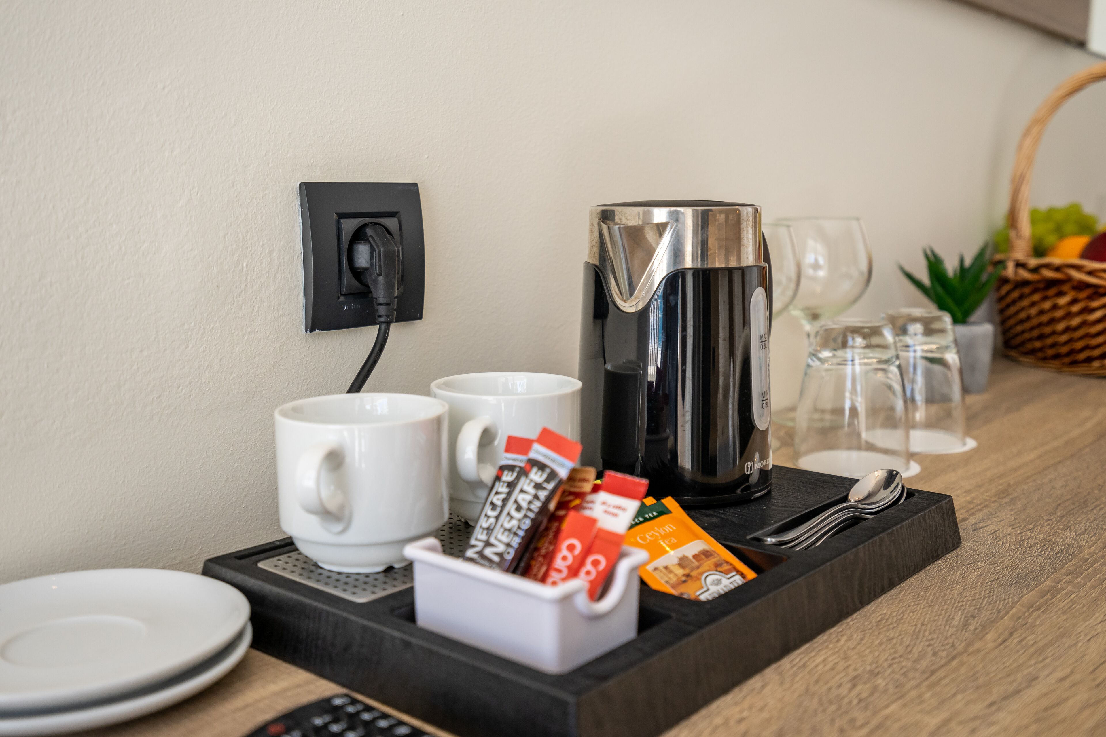 Een ontbijtkarretje met koffiezetapparaat, kopjes en theezakjes.