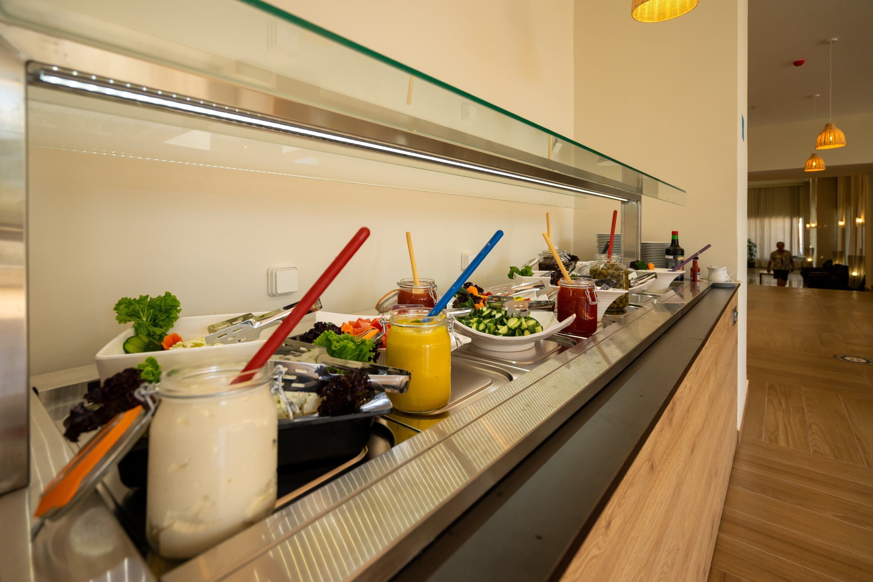 Una mesa de buffet con diversos alimentos y utensilios.