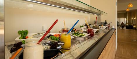 Una mesa de buffet con diversos alimentos y utensilios.
