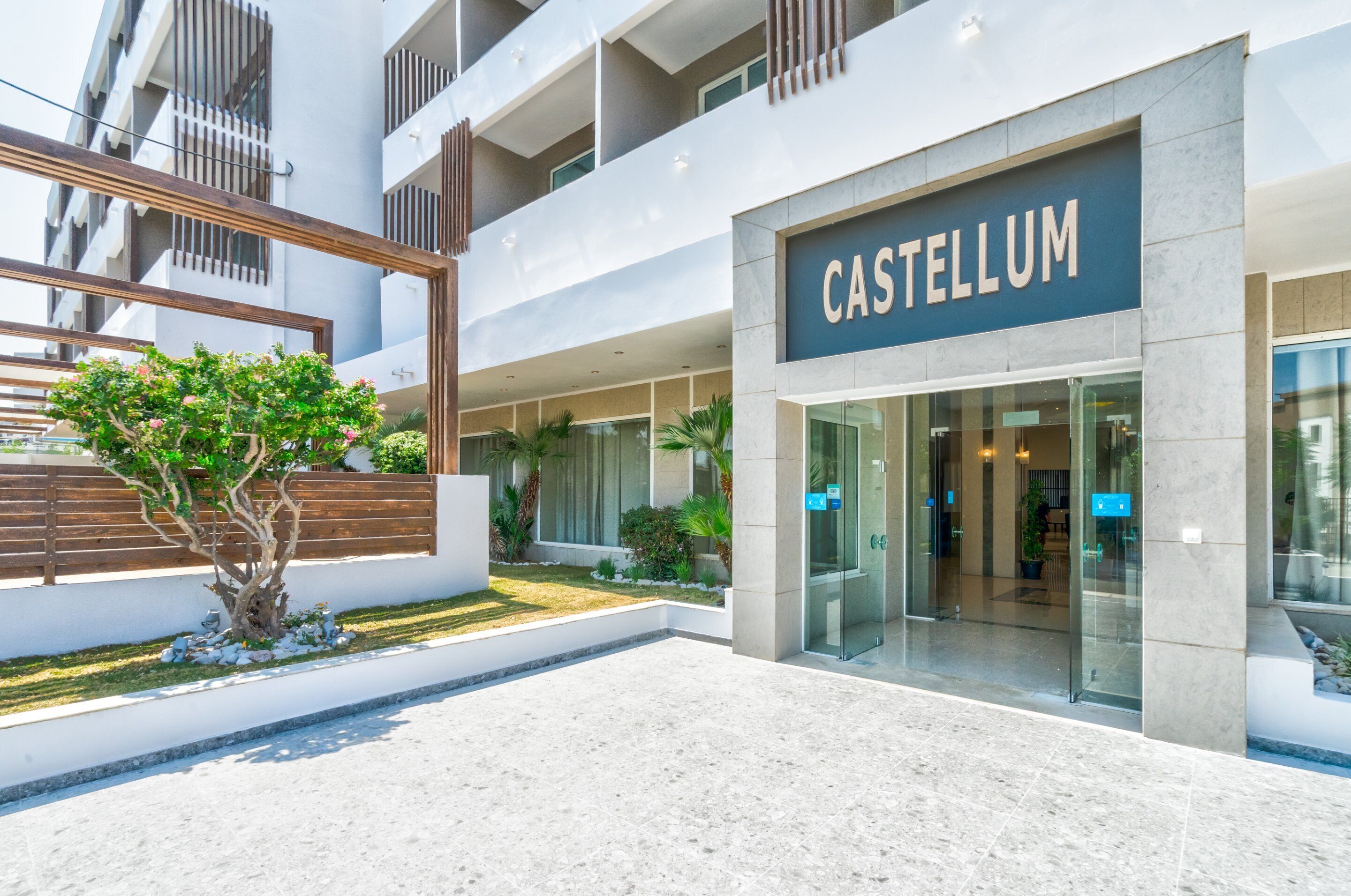 Ein moderner Hotelzugang mit einem Schild, auf dem 'CASTELLUM' steht.