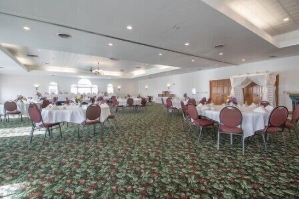 A large banquet hall with round tables and chairs, carpeted floor, and a high ceiling with recessed lighting. - Deer Valley Lodge & Golf (Barneveld)