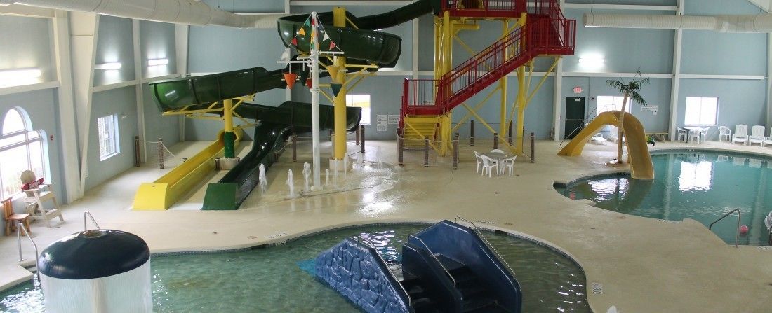 An indoor water park with multiple slides and pools.