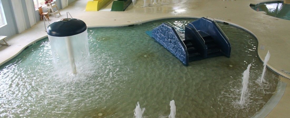 A pool with a water feature and a blue structure.