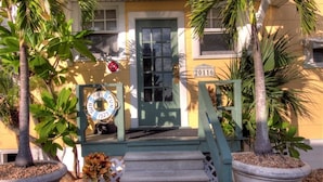A yellow building with a green door and a year plaque. - Sun N Fun Beachfront Vacation Rentals (Indian Shores)