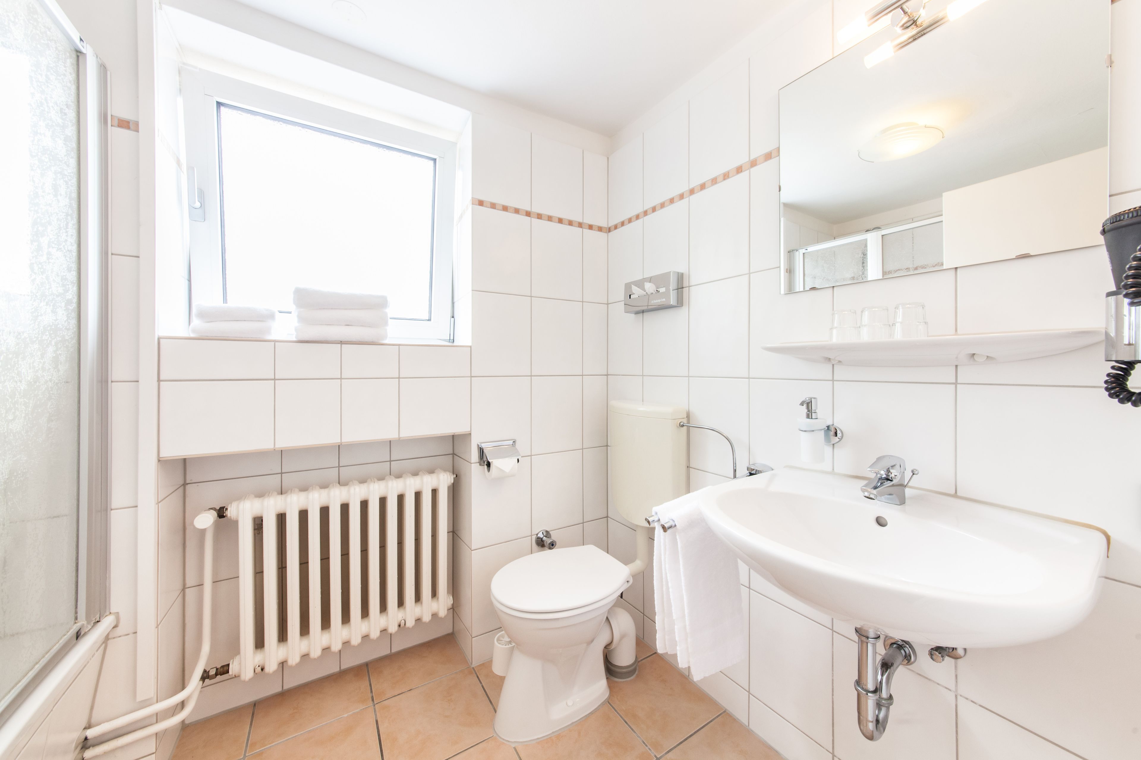 Une salle de bain moderne avec des toilettes, un lavabo et une fenêtre.
