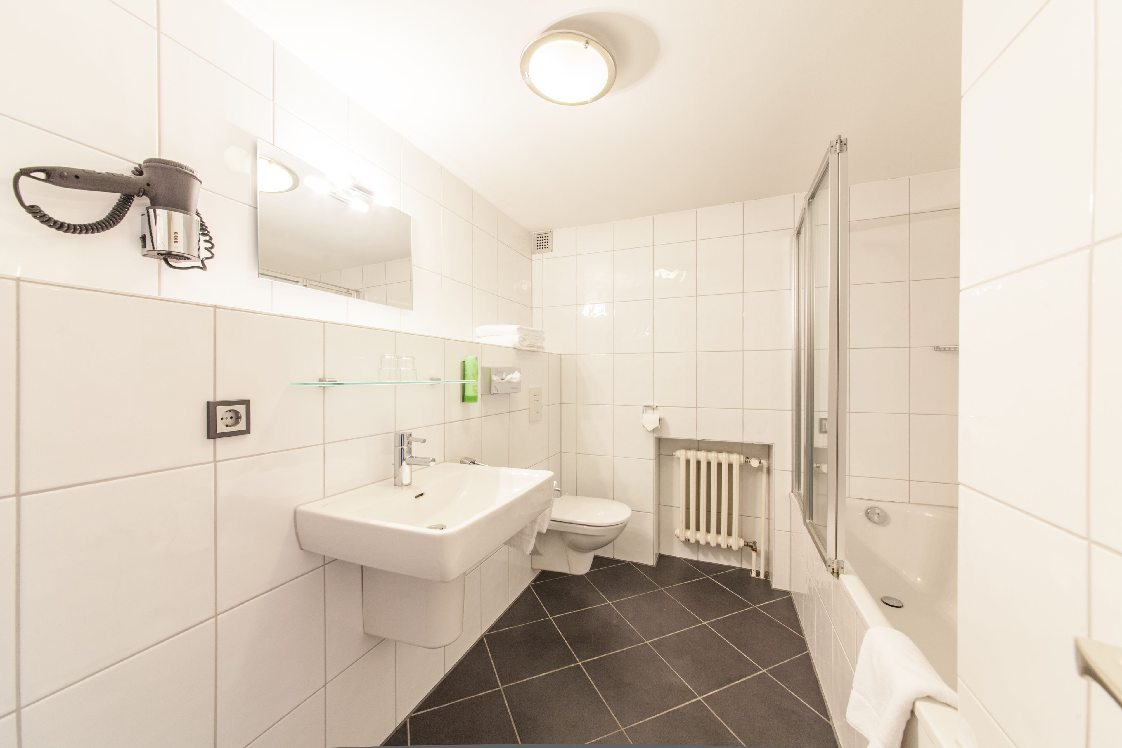 A modern bathroom with a sink, toilet, and shower.