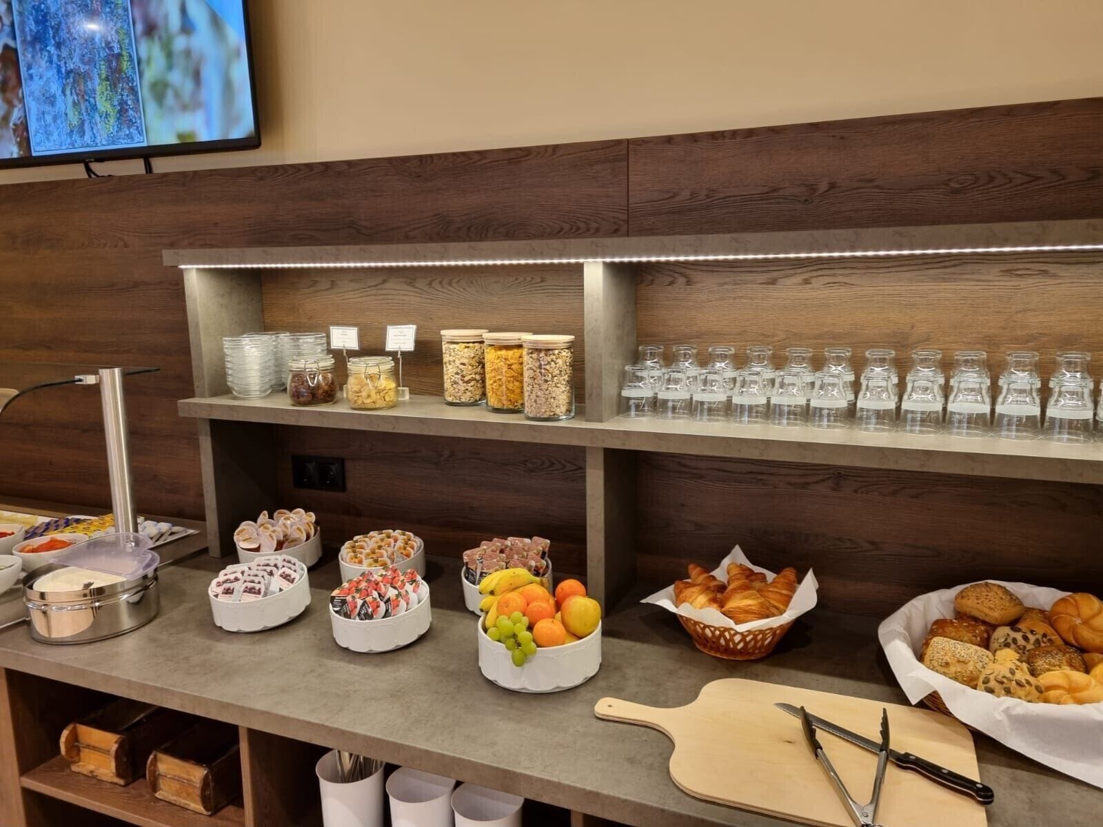 Montaje de bufé con diversos alimentos, como frutas, pasteles y salsas.