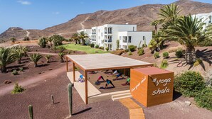 Un studio de yoga doté d’une terrasse en bois et d’une enseigne sur laquelle on peut lire : « Libérez votre esprit, espace de méditation ».