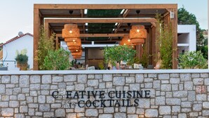 A stone wall with the text "CREATIVE CUISINE AND COCKTAILS" indicating a restaurant or bar. - Sunshine Hotel Lardos (Rhodes)
